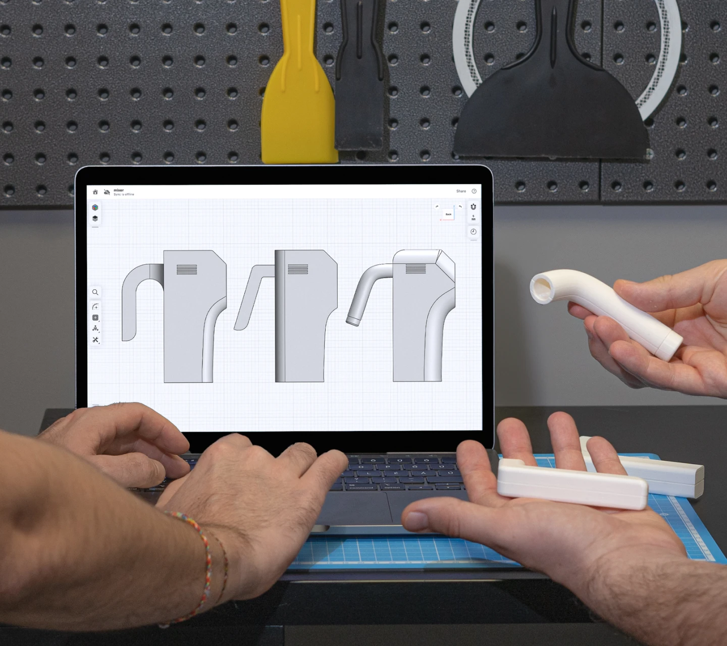 Engineer designing a part in CAD on a laptop